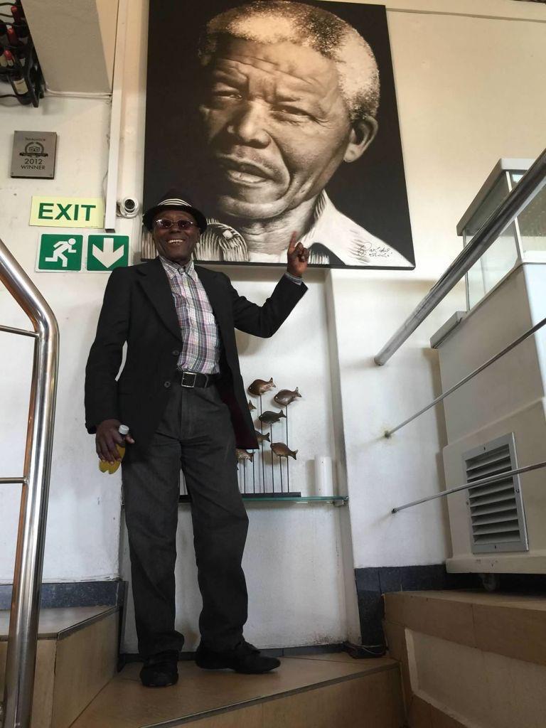 Kofi Ohene Agyekum beneath a portrait of Nelson Mandela